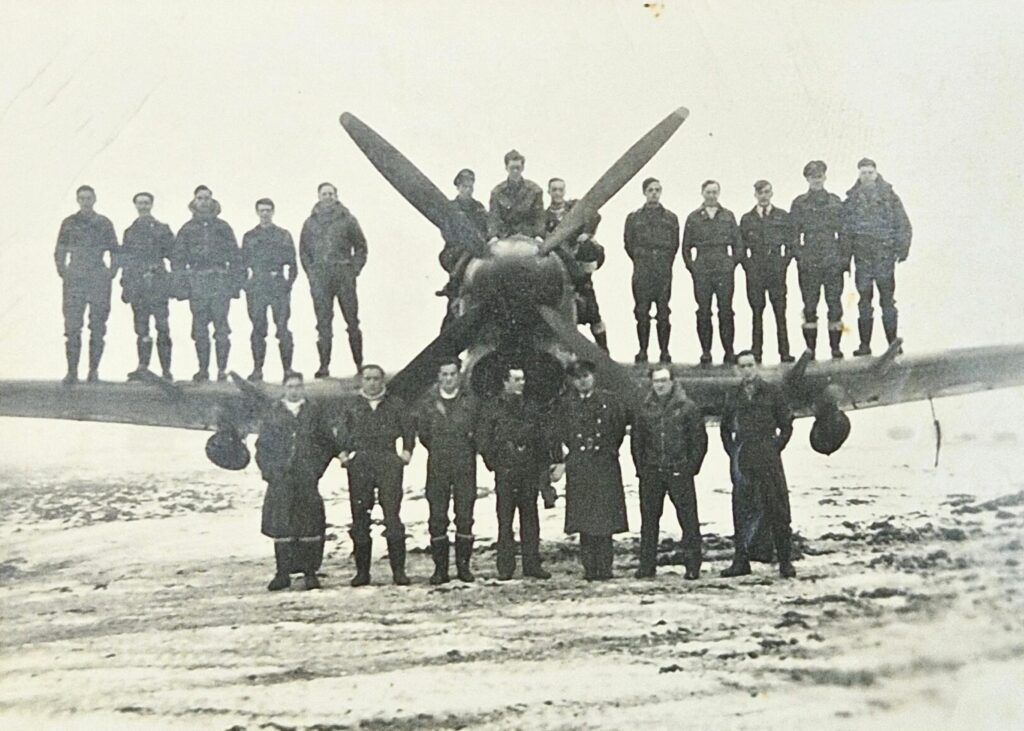 197 Squadron RAF, B Flight, Belgium 1945, Left Wing (L-R) Jonnie Howell, Ted Parkinson, Bob Gibbings, Paddy Byrne, Gerry Mahaffy, Fuselage (L-R) Andre De Bie, ‘Doc’ Horn, D. M. Smith, Right Wing (L-R), Cobber James, Derek Lovell, Derek Tapson, Jimmy James, Johnny Rook, Ground (L-R), Ken Bowman, Red Matthews, Ken Harding, Dicky Curwen, Whittaker (possibly 146 Wing RAF or 84 Ground?), Jock Ellis, Gubby Allen. Probably B.70 Deurne (Antwerp), Belgium January 15, 1945.